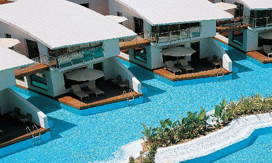Außenpoolanlage des Hotels Cornelia Diamond Golf Resort Spa mit sonnengeschützten Liegemöglichkeiten